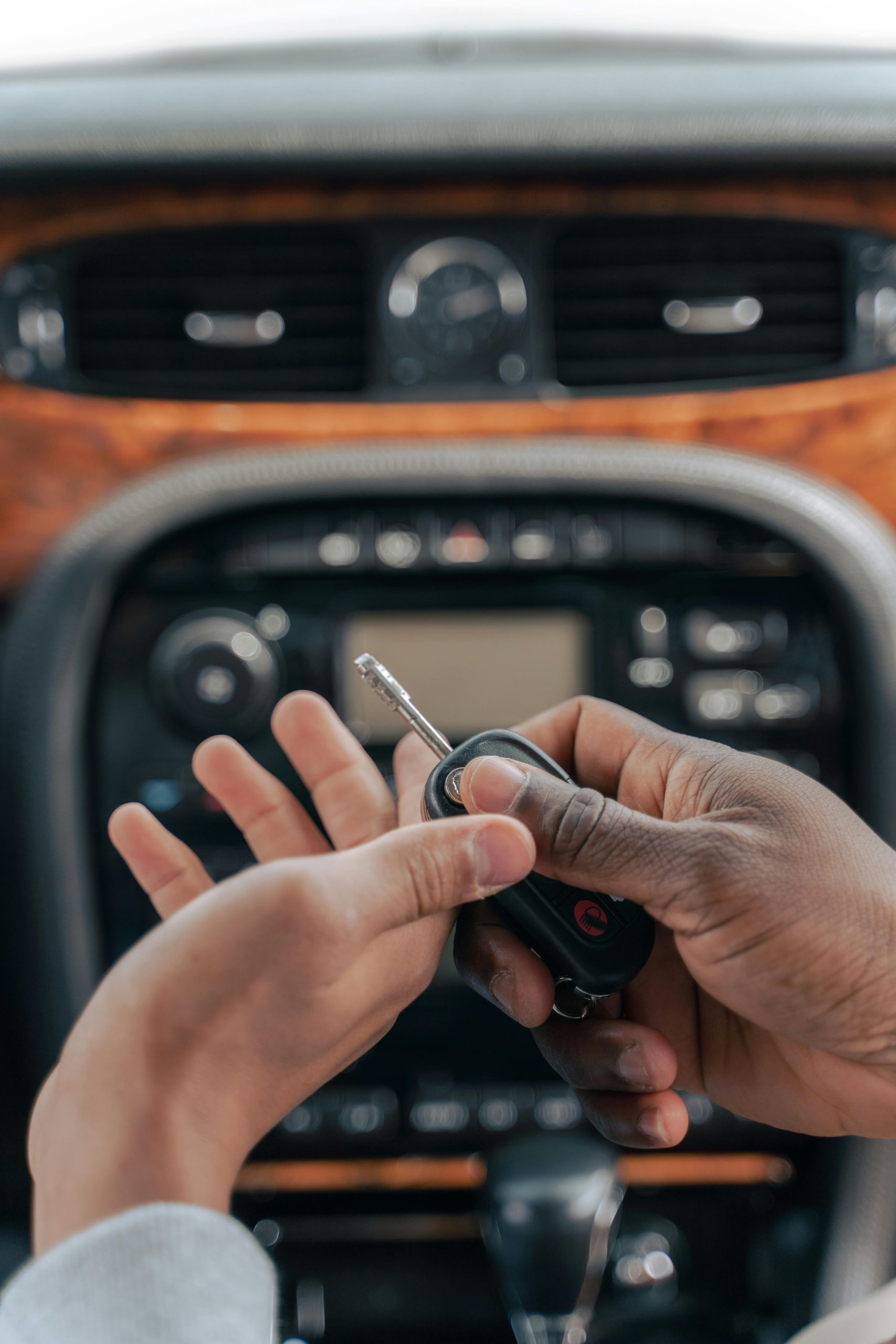 Two people exchanging car keys inside a luxury car, emphasizing guidance and learning.